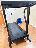 Full view of treadmill from rear showing deck and frame