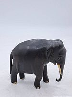 Left side profile of carved wooden elephant showing overall form