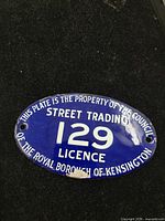 Front view of oval blue enamel street trading licence plaque