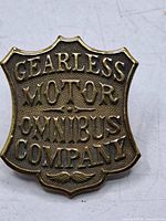 Front of brass operator’s badge showing raised text
