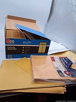 Overall lot showing open box of catalog envelopes, sealed 40-pack, loose envelopes