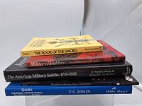 Stack of five military reference books showing spines