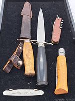 Group shot of all five knives with sheaths and scabbard