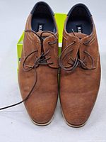Top view of both brown lace-up shoes