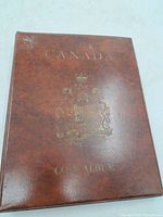 Brown Canada coin album closed showing gold crest and title