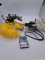 Group shot of all items: yellow air hose, screwdriver set, string lights, white cord, air blow-gun