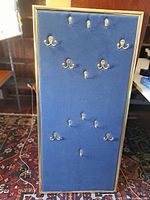 Full view of blue velvet board with brass hooks