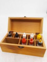 Open wooden box displaying eight reagent bottles