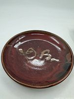 Front view showing burgundy glaze and green accents