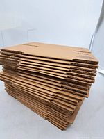 Stack of flat-packed Uline mailer boxes