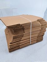 stack of flat corrugated boxes bound with plastic strap