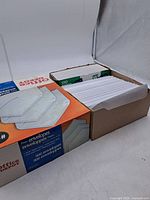 Overall view of open Office Depot envelope box with additional stack of envelopes