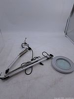 Full view of swing-arm magnifying lamp with clamp and power cord