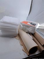 Foam sheets stack, packaged protective wrap, tape roll, multiple paper rolls