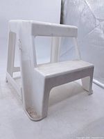 Overall view of white plastic two-step stool showing two steps and structure