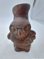 Front view of brown clay effigy vessel shaped as bird figure