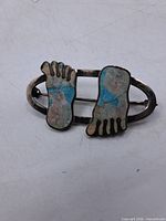 Front view showing footprint motifs and inlay