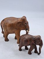 Both wooden elephant figures side by side showing relative sizes