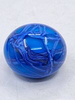 Full view of spherical blue art glass paperweight