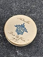 Lid of cardboard case showing printed blue emblem and handwritten title