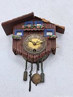 Front view showing dial, chains, weights, pendulum and decorative facade