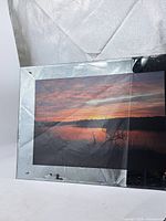 Front view showing sunset image and glass/metal frame