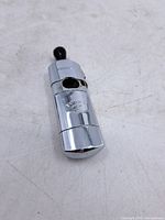 Full view of chrome combination lighter with black mouthpiece attached
