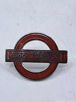 Front of red enamel London Transport badge