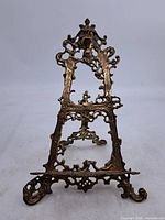 Front view showing full ornate design of brass easel stand