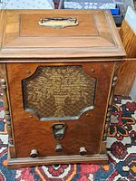 Front view showing cabinet, grille, knobs and dial