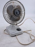 Front view showing fan grille, blades, base, control knob and power cord