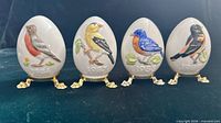 Front view of four Goebel porcelain Easter eggs on stands
