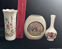 Front view of three vases beside ruler for scale