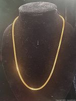 Full view of gold tone chain necklace on bust