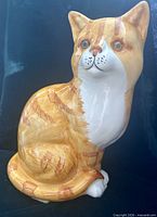 Front view of glazed porcelain orange tabby cat figurine