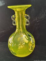 Front view showing bulbous body, narrow neck, flared rim, clear loop handles, swirl pattern