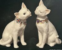 Front view of both porcelain cats facing each other as if kissing