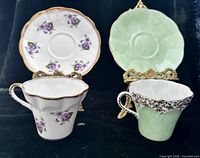 Front view of both teacups and saucers on stands