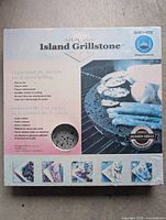 Front of retail box showing Island Grillstone branding and stone sample cut-out