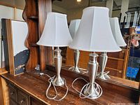 Both lamps side by side on wooden surface with cords visible