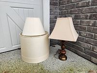Lamp with square shade beside extra drum shade