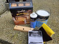 Full kit contents on concrete: box, can, cleaner bottle, block, pad, instructions