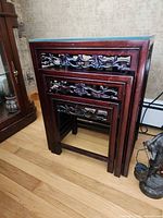 Three nesting tables fully nested showing carved apron and finish