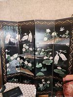 Full view of 4-panel black lacquer folding screen showing painted cranes, flowers, gold border