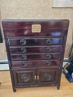 Front view of mahogany Asian-style armoire showing drawers and cabinet doors