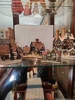 Group shot of multiple David Winter cottages on glass shelf