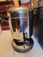 Full view of Farberware stainless coffee urn on table