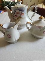 Full view of teapot, creamer and lidded sugar bowl