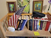 Top shelf with books, flag, prints visible