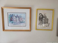 Gold framed color print of row houses, next to yellow framed architectural print